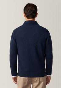 Maglione blu navy a maglia con colletto a scialle, polsini e orlo a coste, e dettagli testurizzati sul retro. Realizzato in un tessuto morbido e spesso per garantire calore.