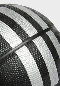 Balón de baloncesto con superficie texturizada, caracterizado por franjas blancas y negras y una costura central. El material es de goma con un patrón de puntos.