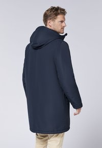 Navy blue insulated coat with a hood, featuring a straight cut, side pockets, and smooth texture. Visible stitching along seams.