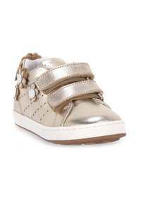 Scarpa da ginnastica metallizzata oro con cinturini in Velcro, dettagli floreali decorativi, design traforato, suola in gomma bianca e suola esterna marrone.