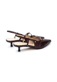 Zapatos slingback de estampado de leopardo rojo y negro con punteras en punta, pequeños tacones de bloque y acentos dorados en las correas. Textura suave.