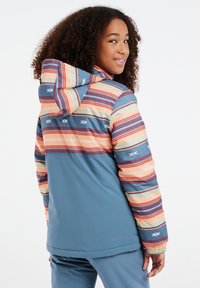 Kleurijke jas met een blauwe basis, multikleurige strepen en witte accenten. Zachte stof met een capuchon en elastische manchetten.