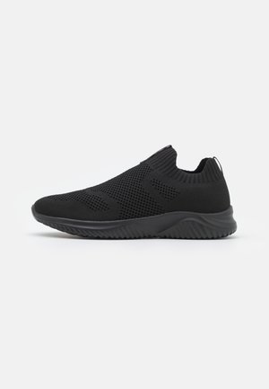 Des chaussures noires à enfiler avec une tige en maille respirante, un motif texturé, un col élastique semblable à une chaussette, et une semelle en caoutchouc avec un design ondulé.