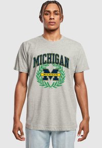 Šedé bavlněné tričko s nápisem "MICHIGAN", modrožlutými akcenty a zeleným vavřínovým vzorem. Krátké rukávy a klasický kulatý výstřih.