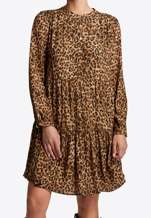 Robe à manches longues imprimé léopard avec col rond boutonné et volants froncés, portée par une personne debout, visible du cou jusqu'aux genoux.