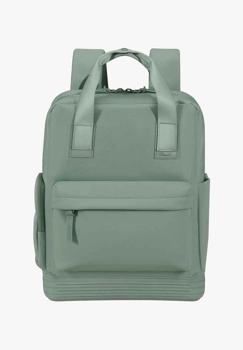 Sac à dos vert avec une finition texturée, deux bretelles rembourrées, une poche frontale et des lignes horizontales à la base pour une meilleure adhérence.