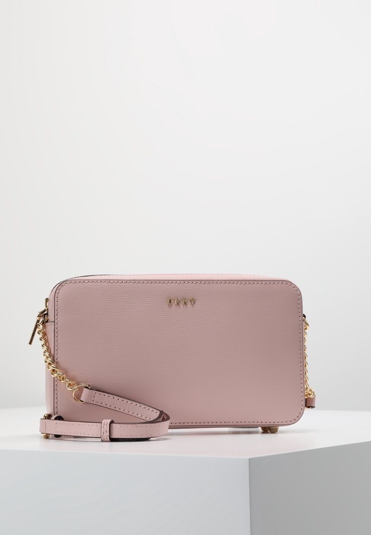 Borsa a tracolla in ecopelle rosa con dettagli in oro, tracolla a catena, chiusura con zip e nome del marchio in rilievo sul davanti. Forma rettangolare.