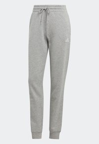 Graue Sweatpants aus weichem Material, mit einem Kordelzugbund und gerippten Knöcheln. Enthält ein weißes Logo am linken Oberschenkel.