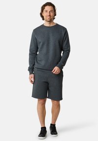 Dark gray sweatshirt and matching shorts in a soft fabric. The sweatshirt has a crew neck and long sleeves; the shorts have a relaxed fit.
