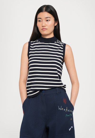 Navy and white striped sleeveless top with a high neckline, paired with dark navy pants featuring colorful embroidery on pockets.