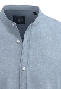 Světlomodrá košile na knoflíky s mandlovým límečkem, vyrobená z jemné, texturované látky. Obsahuje dva bílé knoflíky a značkovou etiketu.