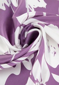Tissu floral à motifs violets et blancs, finition satinée, texture lisse, drapé élégamment en spirale. Apparence douce, légère et lumineuse.