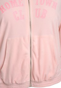 Felpa con cappuccio rosa chiaro con tasche a palloncino. Presenta una scritta in rilievo "HOME TOWN CLUB" nel colore abbinato, polsini e orlo a costine.