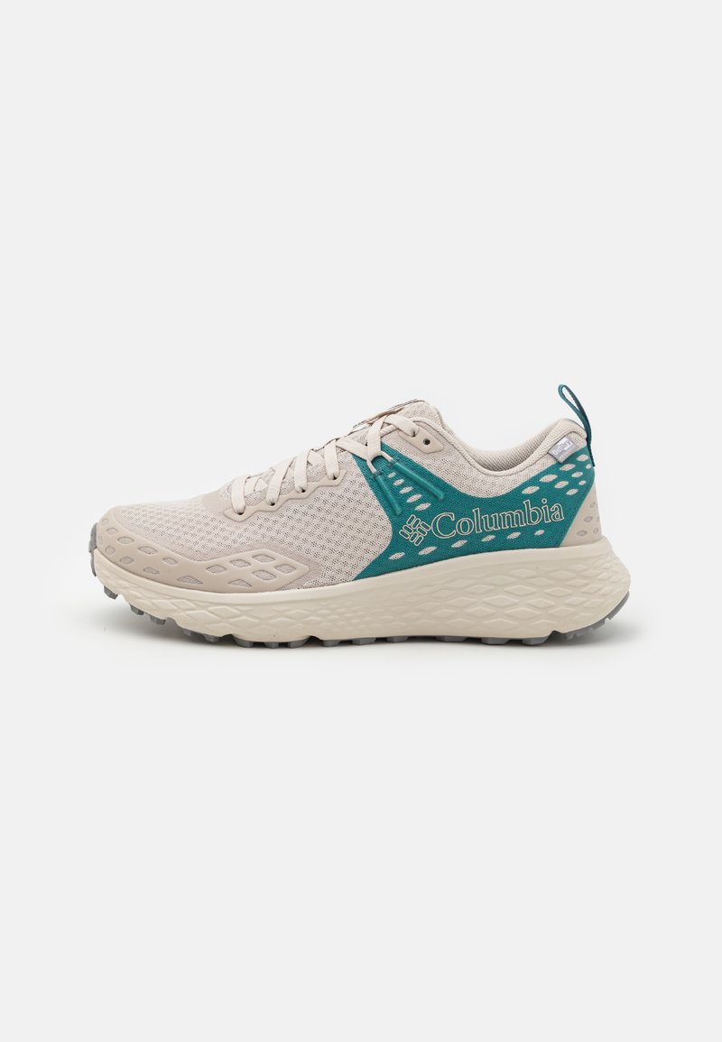 Light beige athletic shoe with a breathable mesh upper, teal accents, textured sole, and "Columbia" branding on the side.