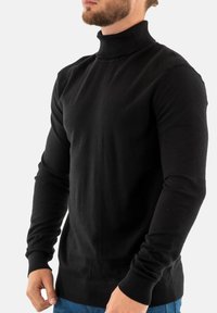 Suéter de cuello alto negro hecho de suave tela de punto, con detalles acanalados en los hombros y las mangas, diseño ajustado y mangas largas.