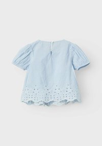 Blusa azzurro chiaro a maniche corte con righe verticali bianche. L'orlo scallop presenta ricami decorativi e dettagli a taglio. Chiusura con bottoni sul retro.