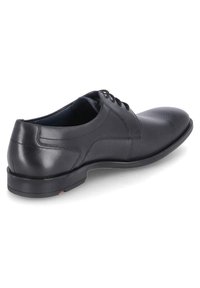 Schwarzer Lederschuh mit glatter Oberfläche, runder Spitze und subtilen Perforationen vorne, ausgestattet mit einer flachen Gummisohle.