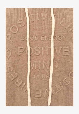 Beiger Hoodie-Stoff mit weißen Kordeln und eingeprägtem Text mit den Worten "Gute Energie", "Positive Mind Club" und "Positive Spiritual".
