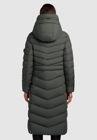 Lange, gehaakte puffercoat in donkergrijs. Heeft chevron-quilting, geribde manchetten en een soepele textuur. Ontworpen voor warmte en bescherming.