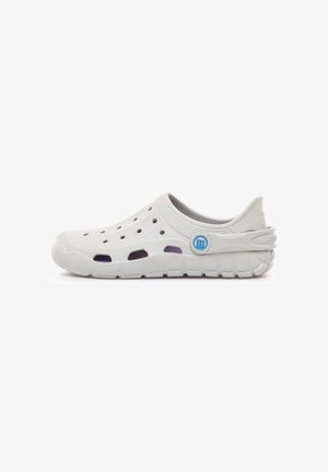 Zueco blanco de goma sin cordones con orificios de ventilación, suela texturizada y correa trasera ajustable con un logo circular azul.