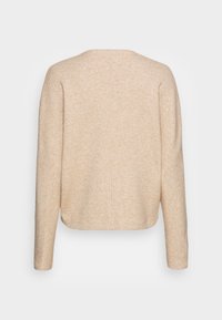 Veste beige à texture douce avec manches longues, encolure arrondie et coupe droite. Un détail de couture verticale longe le dos.