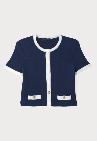 Ναυτικό ριγωτό ζακέτα με λευκό τελείωμα, κοντά μανίκια και μπροστινό κλείσιμο με κουμπιά. Διαθέτει δύο τσέπες με διακοσμητικά κουμπιά.