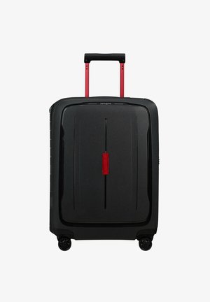 Valise rigide noire avec une finition texturée, dotée d'une poignée télescopique rouge et d'accents rouges, de quatre roues noires et d'un verrou central.