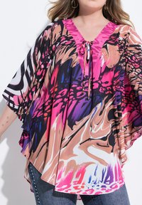 Poncho multicolore con scollatura a V rosa e dettaglio con cintura, caratterizzato da motivi intricati in tonalità di rosa, nero, viola e beige.