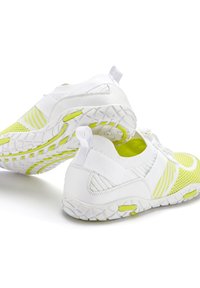 Witte en neongele sportschoenen met een getextureerde gebreide bovenkant, uitgerust met een rubberen zool en trekhaak, ontworpen voor flexibiliteit en ademend vermogen.