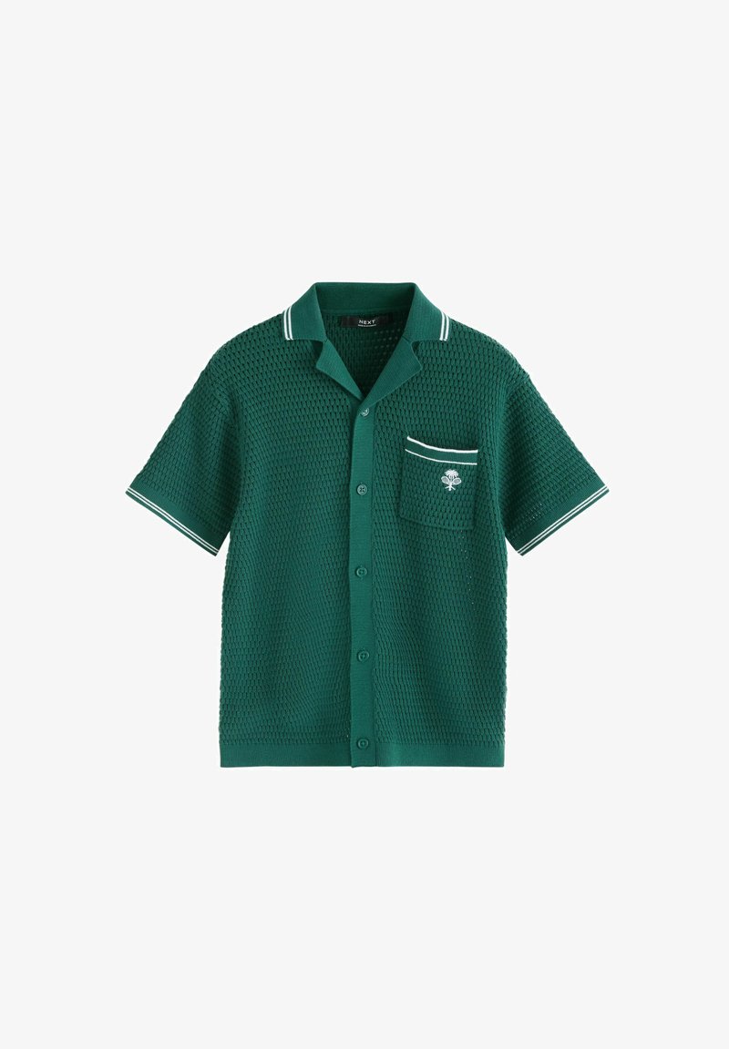 Polo shirt verde a maniche corte con un design a maglia testurizzata, strisce bianche sul colletto e una tasca sul petto con un piccolo logo a forma di albero.