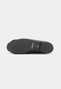 Semelle d'une chaussure noire Gabor indiquant la taille 5 et le texte "Made in Portugal" sur un fond gris clair uni.