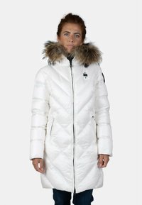 Cappotto invernale bianco imbottito con cappuccio foderato in pelliccia, caratterizzato da una chiusura a zip, design trapuntato diagonale e tasche laterali. Texture liscia e lucida.