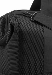 Borsa da viaggio nera in tessuto a rete testurizzata, con zip resistente e tracolla regolabile. Presenta una struttura solida e durevole per versatilità.