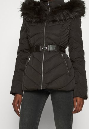 Zwarte pufferjack met nep bont kraag, chevron-quiltontwerp, rits aan de voorkant, twee zijzakken en een brede zwarte riemaccent.