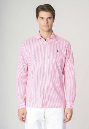 Camicia a maniche lunghe a righe verticali rosa e bianche, con chiusura a bottoni frontale, colletto classico e un piccolo logo blu sul petto.
