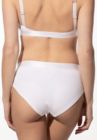 Weiße Baumwollunterwäsche mit einem glatten, nahtlosen Design. Der Bund hat ein satinartiges Finish, und es gibt eine minimale Abdeckung am Rücken.