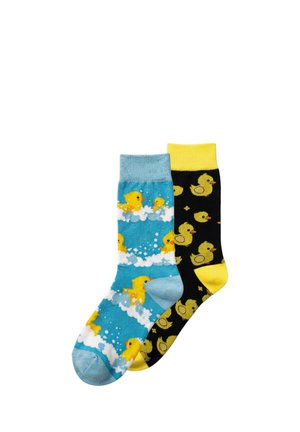 Een paar kleurrijke sokken, één blauwe met gele eendjes die zwemmen in witte bellen, en één zwarte met verspreide gele eendjes en een gele boord.