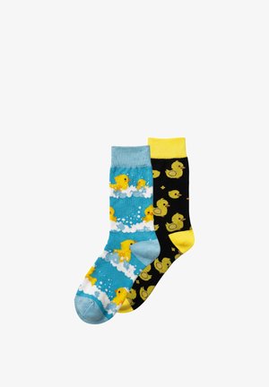 Coppia di calzini colorati, uno blu con paperelle gialle che nuotano in bolle bianche e uno nero con paperelle gialle sparse e polsino giallo.