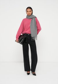 Pink sweatshirt, grey scarf, black wide-leg pants, and black clutch. High-heeled shoes, casual design, soft texture, and simple accents.