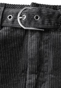 Tissu en velours côtelé gris avec une texture à nervures verticales, accompagné d'une boucle de ceinture en métal et d'œillets, montrant les détails de la ceinture.
