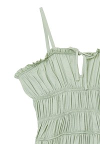 Light green dress with adjustable spaghetti straps, featuring gathered texture, ruffled neckline, and a tie closure at the back.