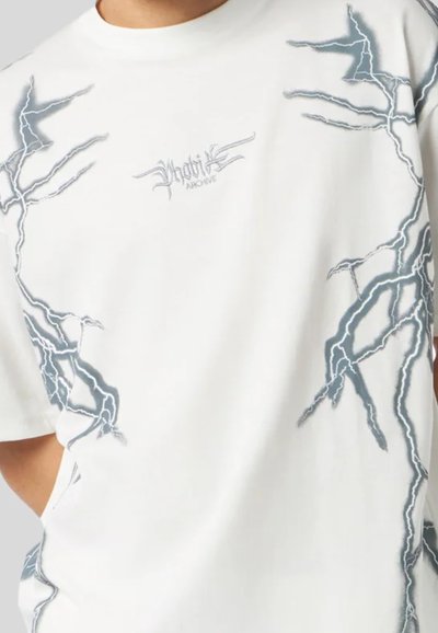 T-shirt bianco con grafiche di fulmini azzurri e testo ricamato che recita "phoenix archive". Tessuto di cotone con una vestibilità comoda.