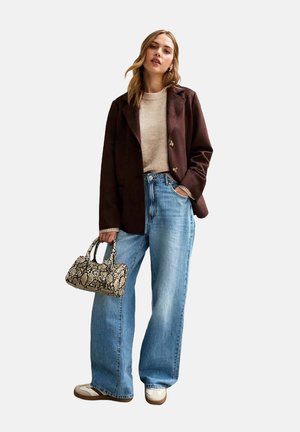 Blazer marron, pull beige, jeans à jambes larges bleu clair, et sac à main en peau de serpent. Baskets blanches avec des accents marron.