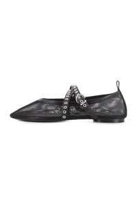 Zapato plano de malla negra con punta afilada y tira al tobillo. Presenta detalles en forma de ojales plateados circulares en la tira y un tacón bajo y plano.