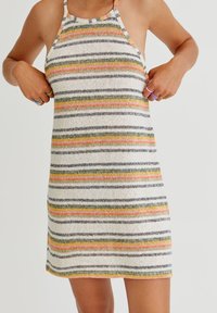 Robe en tricot rayée avec des lignes horizontales en gris, orange, jaune et vert sur un fond clair ; encolure halter avec des bretelles fines.