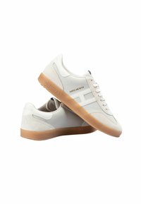 Zapatillas blancas con parte superior de cuero liso y acentos de ante; suela de goma; presenta un logotipo grabado en el lado y el talón.