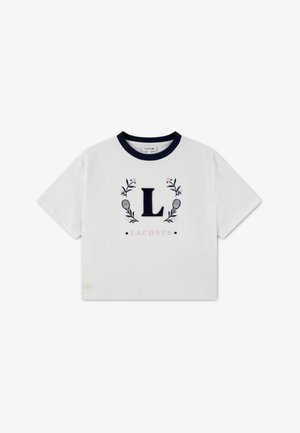 Valge puuvillane t-särk meresinise ümarakaelusega, millel tikitud täht "L" lilleornamentidega ümbritsetuna ja allosas tekst "LACOSTE".