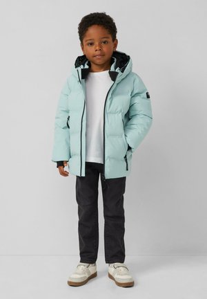 Helle blaue Daunenjacke mit Kapuze, schwarzer Innenausstattung, Reißverschluss und Seitentaschen. Kombiniert mit schwarzen Jeans und weißen Sneakern.