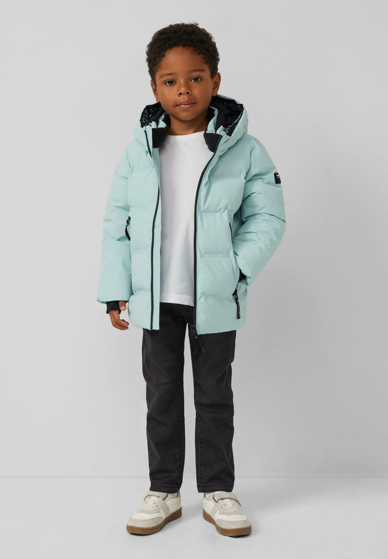 Šviesiai mėlynas pūkinis švarkas su kapisonu, juoda vidinė pamušalas, užtrauktukų uždarymas ir šoninės kišenės. Derinamas su juodomis džinsomis ir baltais sportbačiais.