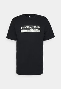 Black cotton t-shirt featuring a rectangular graphic with the text "NIKE AIR" in white over a cloudy background. Short sleeves, crew neck design.